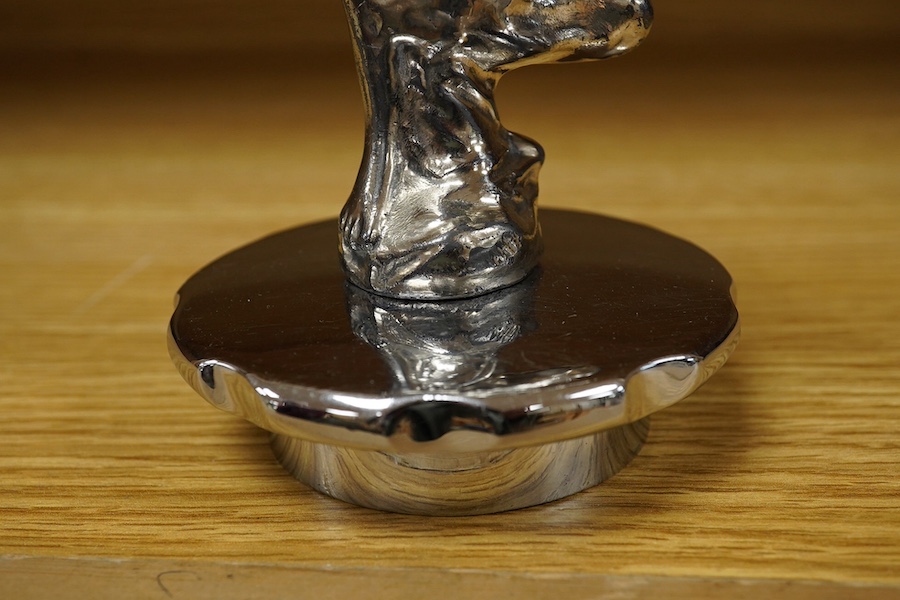 A Sykes style chromed car mascot in the form of an Art Deco woman with flowing gown, indistinctly signed to the base and dated 1922, mounted on a threaded radiator cap. Condition - fair to good.